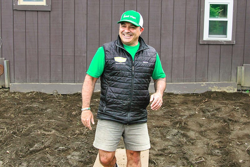 Mike "The Seed Man" Lizotte standing in front of a barn