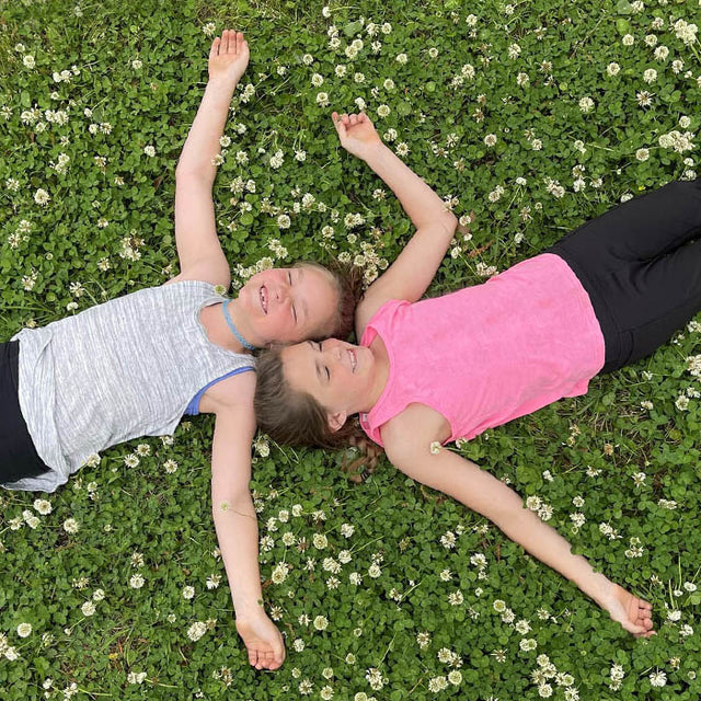 children laying on a clover lawn
