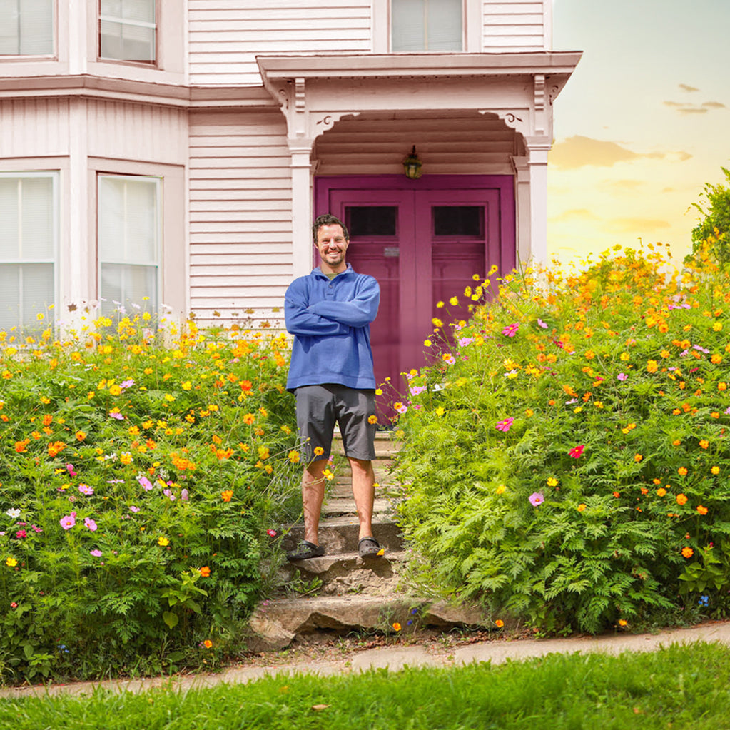 Man standing in front of home with wildflowers