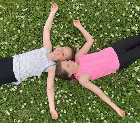 Children lying on a lawn covered in clover