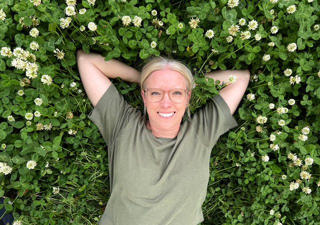 woman lying in clover lawn